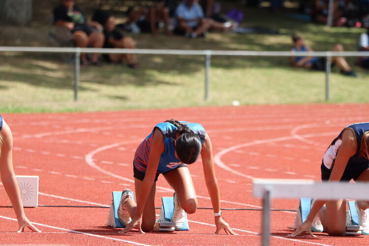 Students at the starting blocks, preparing to sprint at a track event.