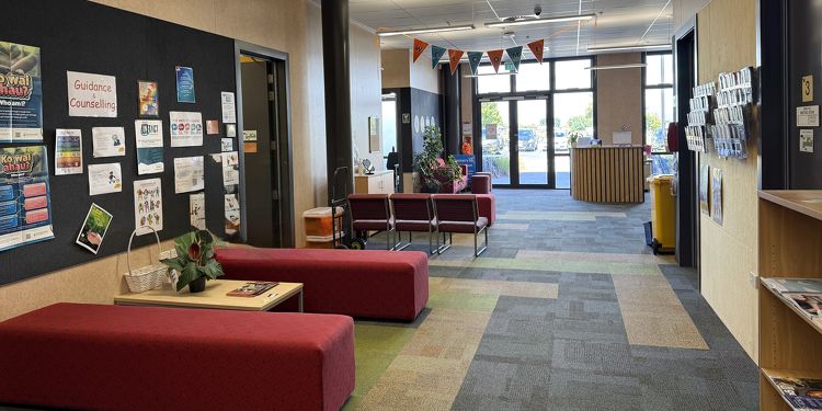 Rototuna High School's student services or counselling area with red seating, noticeboards, and guidance posters.