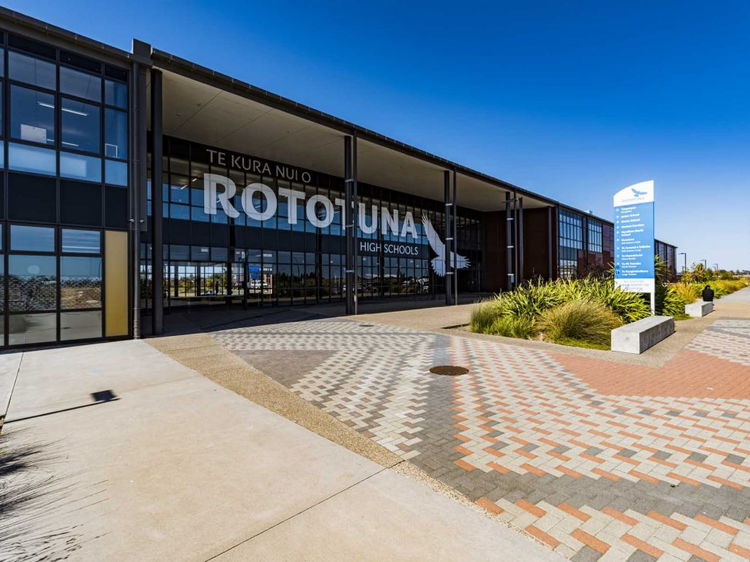 Exterior of Rototuna High Schools building showing the main entrance under a bright blue sky.